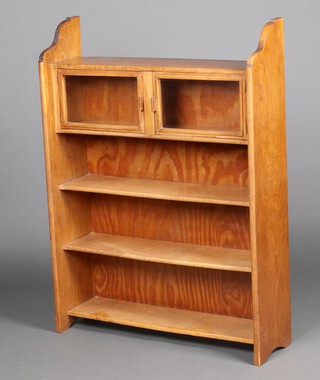 An Art Nouveau light oak bookcase with plywood back, fitted a cupboard enclosed by glazed panelled doors above 3 shelves, 117cm h x 87cm w x 25cm d 