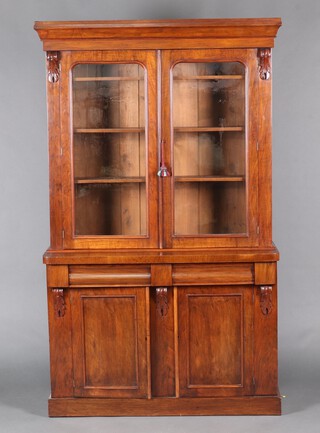 A Victorian mahogany bookcase on cabinet with moulded cornice, fitted adjustable shelves enclosed by arched panelled doors, the base fitted 2 secret drawers above cupboard enclosed by panelled door 201cm h x 120cm w x 45cm d 