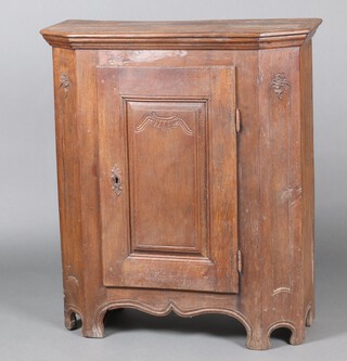 A 19th Century Continental carved elm side cabinet with shelved interior enclosed by a panelled door, raised on bracket feet 109cm x 95cm w x 38cm d 