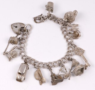 A silver multi link charm bracelet hung numerous charms with padlock clasp, 18cm, 42 grams gross 