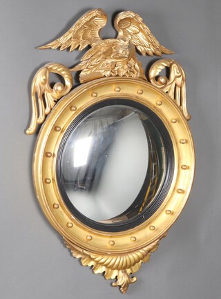 A Regency convex plate mirror contained in a gilt plaster and wooden ball studded frame surmounted by a figure of an angel with wings outstretched 103cm x 65cm 