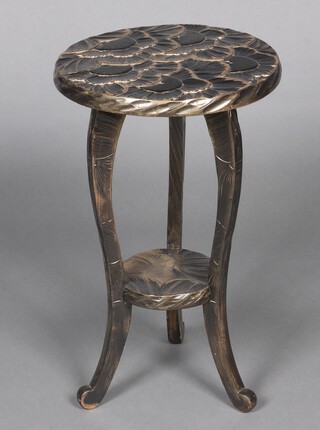 A circular Japanese Liberty style 2 tier occasional table, the top with carved leaf decoration, raised on shaped supports 61cm h x 37cm diam.  