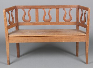 A Continental oak hall bench/window seat with lyre slats to the back and solid seat, raised on square tapered supports 82cm h x 115cm w x 30cm d 