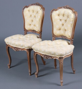 A pair of 19th Century Continental walnut show frame salon chairs, heavily carved throughout, with upholstered seats and backs, raised on cabriole supports 90cm h x 49cm w x 46cm d 