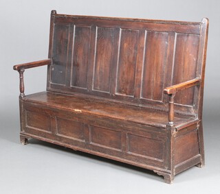 An 18th Century oak settle with raised panelled back and hinged seat with panels to the front 120cm h x 169cm w x 50cm d 