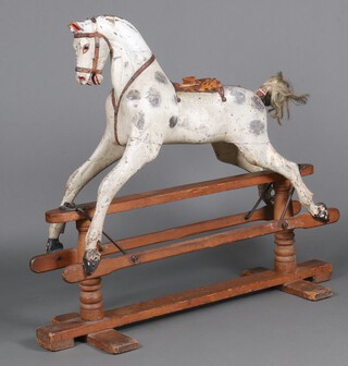 Attributed to J R Smith, a late 19th Century dapple grey rocking horse with glass eyes, raised on a beech cruciform base 125cm h x 133cm l x 46cm w 