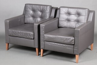 Boss, a pair of armchairs upholstered in black leather material, raised on square supports 75cm h x 72cm w x 82cm (some wear to the arms)