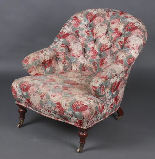 A Victorian mahogany tub back chair upholstered in floral buttoned material 
