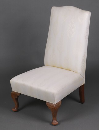 A nursing chair with white and gold upholstery, raised on cabriole supports 