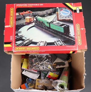 Various transformers, model plastic train railway layout buildings, Hornby turn table etc, contained in a cardboard box