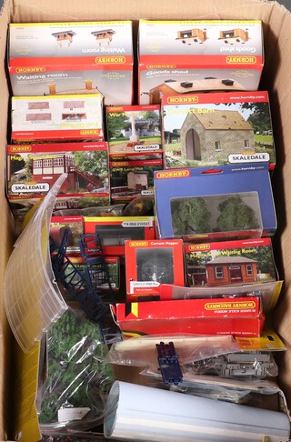 A collection of Hornby railway model train buildings, all boxed, contained in a cardboard box  