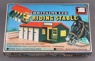 Britains Limited, a boxed plastic riding stable no.4730 together with a quantity of home hand knitted dolls clothing 