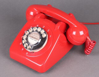 A vintage red plastic dial telephone 