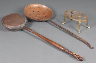 An oval brass footman 12cm x 30cm, a copper and brass cream skimmer and copper warming pan 