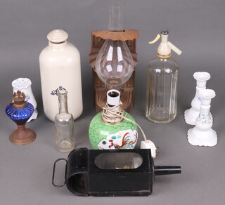 A Royal Doulton hot water bottle, a japanned coaching lamp, a wall oil lamp, a soda siphon, pair of pottery candlesticks and other decorative items 