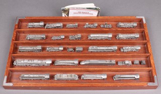 24 various pewter model locomotives, contained in a wooden frame 
