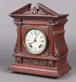 A striking mantel clock with 9cm silvered dial, Roman numerals, contained in an oak case, complete with pendulum and key (currently running)