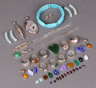 A green hardstone heart shaped pendant and an oval hardstone pendant in a silver mount 