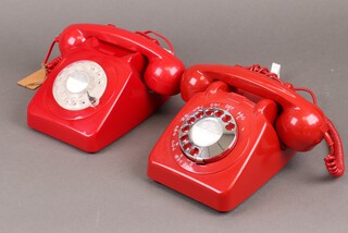 A 1970's red dial telephone the base marked 706.L.TEA64/2A together with a reproduction ditto 