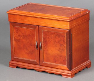 A walnut finished jewellery box with hinged lid, the interior fitted a trays and 8 drawers enclosed by panelled doors 33cm h x 41cm w x 24cm d 