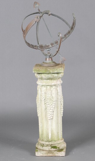 A metal armillary sphere raised on a well weathered reeded concrete base with grape decoration 125cm h 