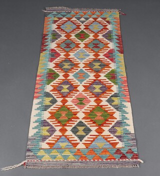 A white, brown and green ground Chobi Kilim runner with all over diamond design 152cm x 59cm 
