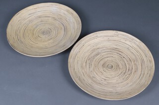 A pair of circular woodgrain effect chargers 67cm diam. 