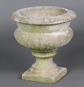 A circular well weathered concrete garden  urn, raised on a square base 33cm h x 32cm diam. 