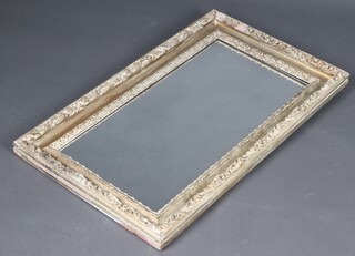 A rectangular plate mirror contained in a Rococo style carved plaster frame 79cm x 38cm (some plaster missing) 