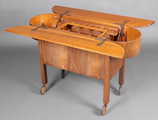 An Art Deco oval mahogany and ply Surprise drinks trolley 75cm h x 114cm x 41cm d 