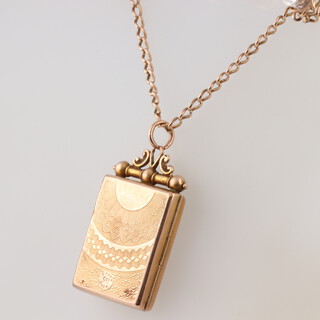A mixed metal, some parts testing as gold locket hung on a ditto chain