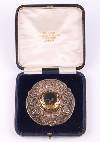 A Scottish silver plaid brooch decorated a mythical beast set citrine to the centre, the reverse engraved Caledonian Society of Horsham, presented to Mr David Brice, Honorary Secretary 1908-1913 as a mark of esteem December 31st 1913, Glasgow 1913, maker Thomas Kerr Ebbutt, 127 grams gross, with fitted case 