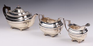 A Georgian style matched silver 3 piece tea service with gadrooned border, raised on bun feet, comprising teapot with ebony handle and finial Sheffield 1911, twin handled sugar bowl and cream jug, Sheffield 1939, by J Richard Attenbrough & Co, 1178 grams gross