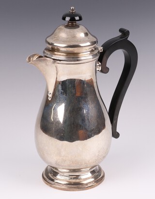 A Queen Anne style silver hot water jug of baluster form with ebonised handle and finial, London 1938 by Joseph Walton & Co, marks rubbed, 356 grams 