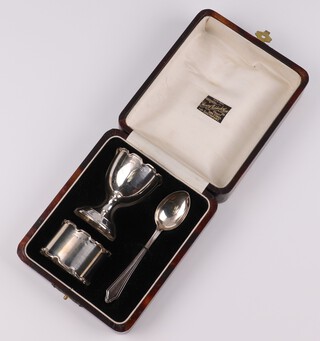 A 3 piece matched silver christening set with egg cup Birmingham 1931, napkin ring Birmingham 1932 and a spoon Chester 1929, 50 grams, in presentation case 