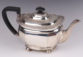 A silver teapot of panelled form, with ebonised handle and finial, raised on bun feet Sheffield 1924 by Atkin Brothers, 720 grams 
