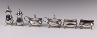 A 4 piece silver condiment set comprising pair of salts and pair of mustards, Birmingham 1920 by E S Barnsley & Co. the mustards with blue glass liners, together with 2 silver peppers, 191 grams 