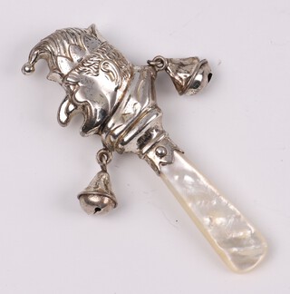 An embossed white metal baby's rattle in the form of Mr Punch with mother of pearl teething bar 