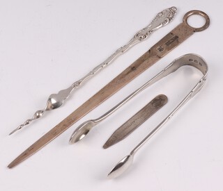 A pair of Victorian silver sugar tongs London 1892, a silver meat skewer Birmingham 1976, a silver RAC golf ball marker and a Sterling silver butter pick, 91 grams 