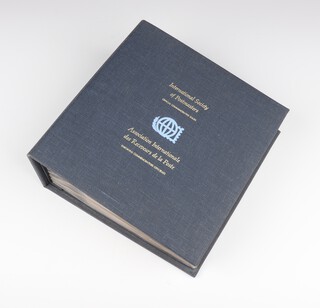 A collection of 35 Franklyn Mint first day covers commemorating The International Society of Postmasters dated late 1970's, each with a Sterling silver commemorative medallion, all contained in a gilt and cloth bound lever arch file 
