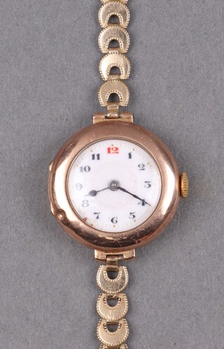 A lady's 9ct gold cased wristwatch with enamelled dial and Arabic numerals, having a rolled gold integral bracelet 