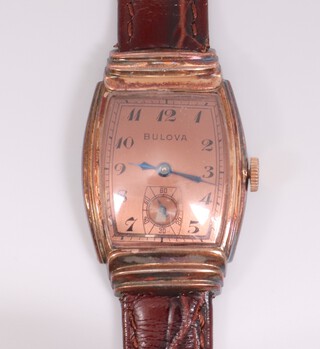 A vintage Bulova wristwatch with coppered dial, Arabic numerals, contained in a gold plated case with leather strap
