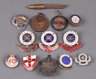 A silver ARP lapel badge, a British Legion lapel badge, Royal Life Saving Society bronze medal, 4 Royal Life Saving Society enamelled badges, Honorary Instructor (x2), Life Member, Life Governor, an England Football Supporters Association enamelled badge, a Red Cross and St Johns War Organisers badge, a YMCA The Order of Red Triangle badge, a St. John Ambulance badge and a badge marked Liberty Fraternity Equality 