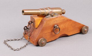 A Victorian model of a 64 Pounder cannon, the 13cm barrel with nitro proof mark, raised on a wooden gun carriage 