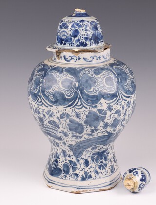 An 18th Century Delft blue and white urn and cover decorated peacocks, of waisted form on an octagonal base 28cm 