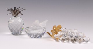 A Swarovski Crystal paperweight in the form of a pineapple 10cm and a bowl in the form of a bird bath with 2 birds 6cm and an ornament in the form of a bunch of grapes  