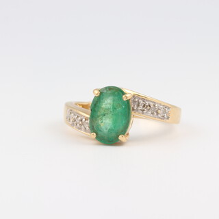 An 18ct yellow gold oval emerald and gem set ring, size N  4.7 grams