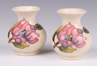 A pair of Moorcroft white glazed Magnolia pattern vases, of squat form, base impressed Moorcroft Made in England 9cm 