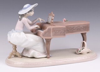 A Lladro figure of a girl seated at a grand piano "Spring Recital"  6452 29cm 