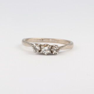 A white gold, testing as 18ct 3 stone diamond ring, size N 1/2, 2.8 grams 
